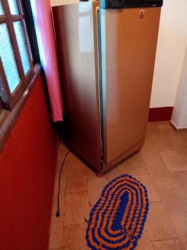 a rug on the floor next to a refrigerator at Pousada Enseada do Coqueiro in Guarapari