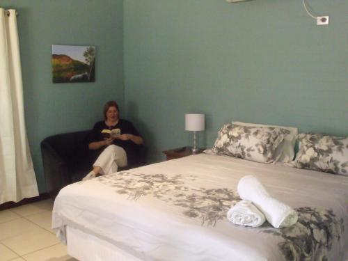 a woman sitting on a couch next to a bed at Margaret House in Margaret River Town
