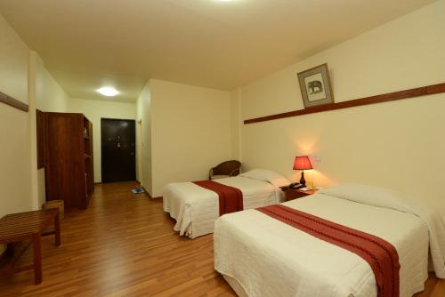 a hotel room with two beds and a table at Bagan Thiripyitsaya Sanctuary Resort in Bagan