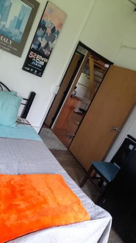 a bedroom with a bed and a door and a chair at Cabañas en el Bosque in Borrero Ayerbe