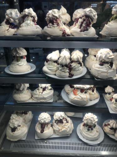 a display case filled with lots of cakes on plates at Pod Neptunem in Międzyzdroje