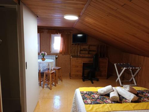 1 dormitorio con 1 cama y escritorio en una habitación en Casita da Floresta, en Ferreira do Zêzere