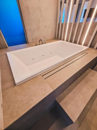 a bath tub with a sink in a room at Viva Mare Studios in Astypalaia Town
