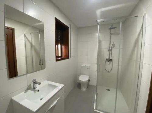 a white bathroom with a sink and a shower at AMARÉ Guest House in Ovar