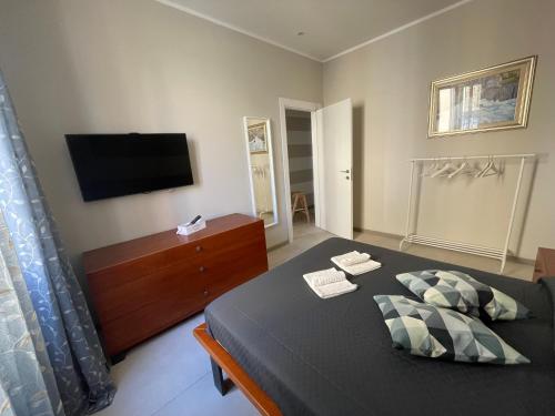拉斯佩齊亞的住宿－IL BARICENTRO，卧室配有一张床,墙上配有电视。