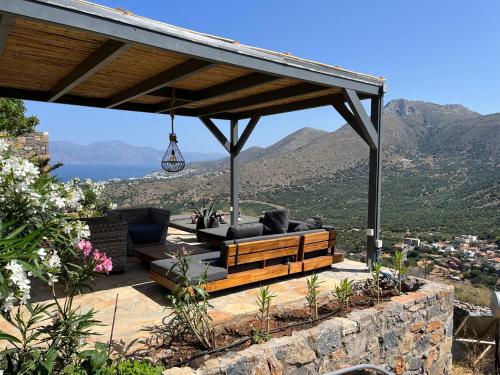 a pergola with a couch and chairs on a patio at Villa Estée, luxury villa with private infinity pool and jacuzzi in Elounda