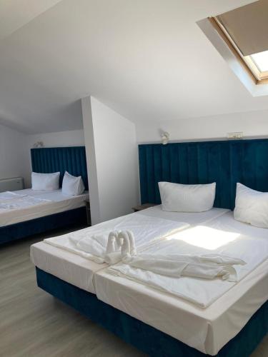 ein Schlafzimmer mit zwei Betten, auf denen Handtücher liegen in der Unterkunft ADMAR Rooms & Restaurant in Costinești