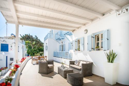 patio z krzesłami i stołami w budynku w obiekcie Matogianni Hotel w mieście Mykonos