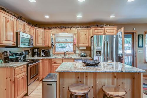 a kitchen with wooden cabinets and a stainless steel refrigerator at Oasis In the Mountains in Murphy