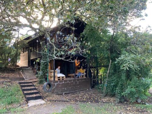 une petite maison avec des personnes assises devant elle dans l'établissement The Tree House, à Hacienda Estela