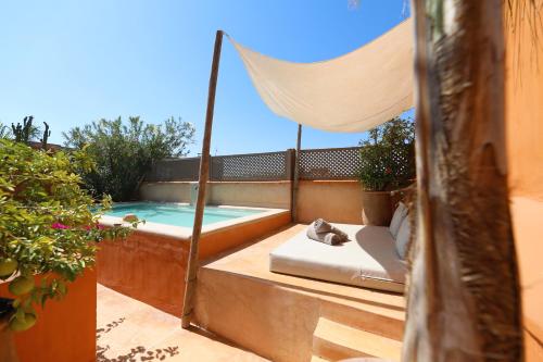 a balcony with a hammock and a swimming pool at Dar Akal in Marrakech