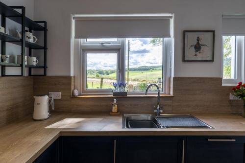 a kitchen with a sink and a window at Wilsons Cottage in Falkirk