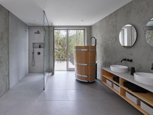 een badkamer met een douche, 2 wastafels en een bad bij Tauhaus in Manětín