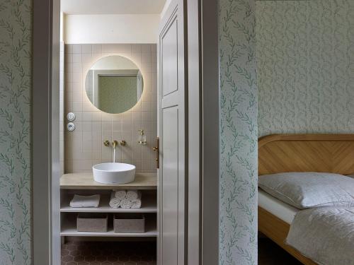 a bathroom with a sink and a bed at Tauhaus in Manětín
