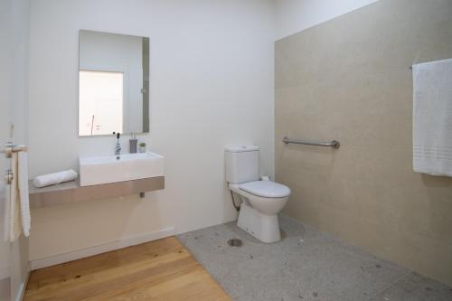 a bathroom with a white toilet and a sink at Varandas de S. Jorge - Apartments in Arcos de Valdevez