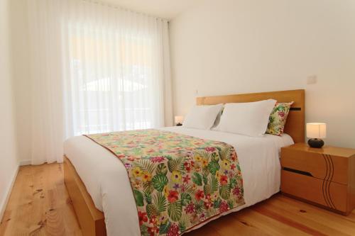Un dormitorio con una cama grande y una ventana en Varandas de S. Jorge - Apartments, en Arcos de Valdevez