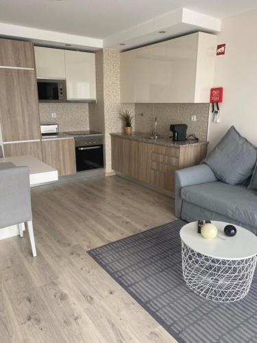 a living room with a couch and a kitchen at Elite Residense a 150 mts Praia da Rocha in Portimão