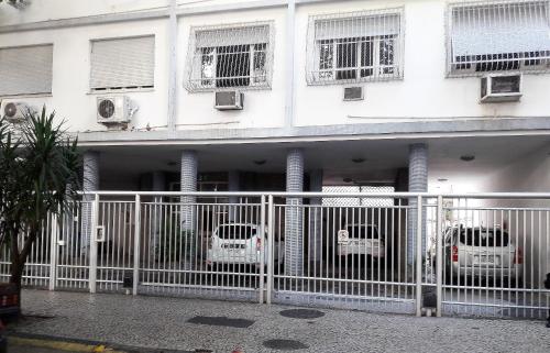 un edificio blanco con tres coches estacionados frente a él en RIO DE JANEIRO - LEBLON BEACH, en Río de Janeiro
