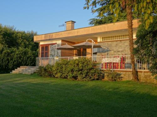 a house with a lawn in front of it at Casa Gaiani Villetta in riva al lago vista mozzafiato in Varano Borghi