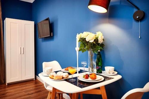 a table with plates of food and a vase of flowers at Residence Vaclavska in Prague