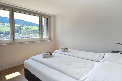 - 2 lits dans une chambre avec 2 fenêtres dans l'établissement Dream View Apt With Homecinema Netflix & Loggia, à Lucerne