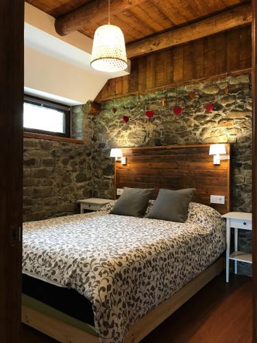 a bedroom with a bed and a stone wall at Arties Centro 2 habitaciones, exclusivo familias in Arties