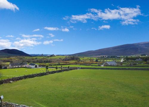 un campo verde con una fattoria in lontananza di Woodview Bed & Breakfast a Kilkeel