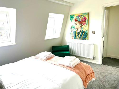 a bedroom with a white bed with a green chair at Weston Inn in Weston-super-Mare