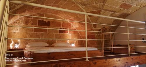 a bed in a room with a stone wall at Casa vacanze salento Vicosoluna in Morciano di Leuca