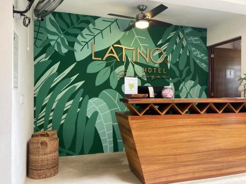 a lush green wall with a lending hotel sign on it at Latino Hotel Boutique in Tulum