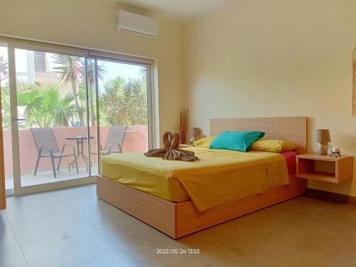 a bedroom with a bed and a balcony with a table at Callista sea view or garden in Kissamos