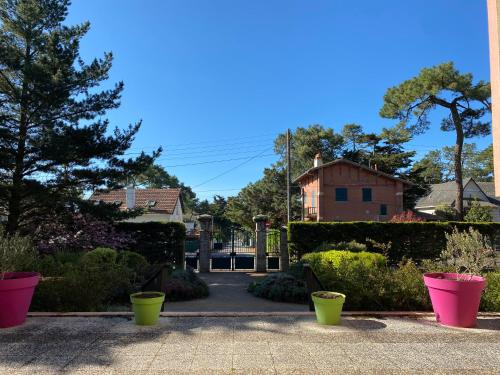 a garden with pink and green pots on a sidewalk at Les terrasses de la Baule in La Baule