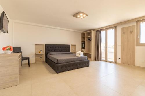 una camera con letto, scrivania e TV di Room Salento Palace a Torre San Giovanni Ugento