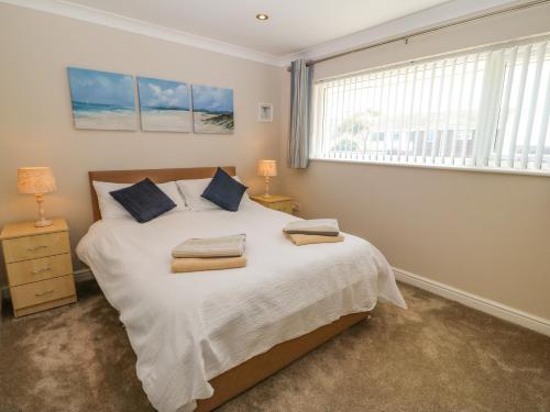 a bedroom with a large bed with a window at St Winifreds in Rhosneigr