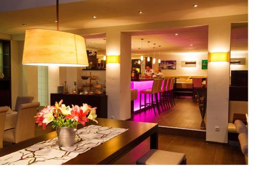 a dining room with a table with flowers on it at Hotel-Restaurant Bellevue in Ruhpolding