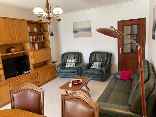 a living room with couches and a flat screen tv at Praia Mar in Monte Gordo