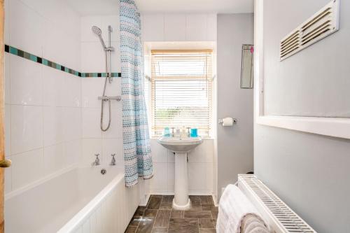 BramhamCabbage Hall Cottage的白色的浴室设有水槽、浴缸和卫生间。