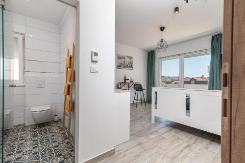 łazienka z toaletą oraz kuchnia z oknem w obiekcie Apartmani Princi Trogir w Trogirze