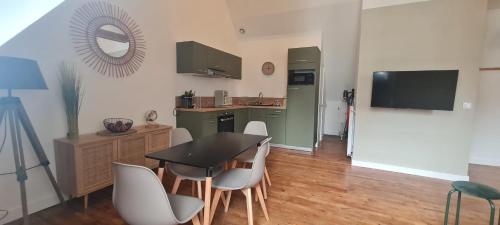eine Küche mit Tisch und Stühlen in einem Zimmer in der Unterkunft Le Rivoli - T3 - dernier étage in Pontivy
