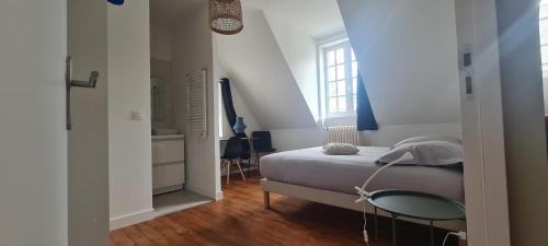 une chambre avec un lit et une table en verre dans l'établissement Le Rivoli  T3  dernier étage, à Pontivy