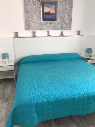 a bed with a blue comforter in a room at Cozy apartment in Los Cristianos in El Guincho