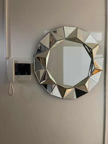 a mirror hanging on a wall with a clock at NewSuites in London