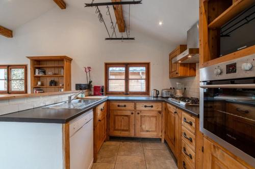 cocina grande con armarios de madera y fregadero en Charming Chalet With Garden In Les Houches, en Les Houches