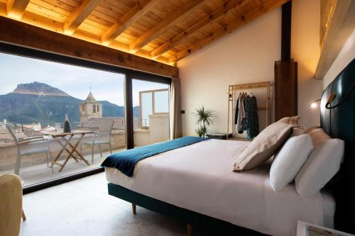 - une chambre avec un lit et une grande fenêtre dans l'établissement Hotel Poeta Jorge Manrique, à Segura de la Sierra