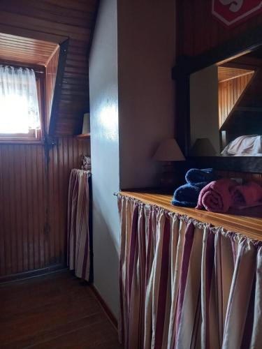 a bedroom with a bed with a wooden wall at Bongusto Apart House Locações Mantiqueira in Monte Verde