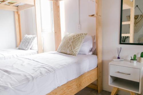 - une chambre avec 2 lits et un miroir dans l'établissement Sayunique Boutique Hostal, à Sayulita