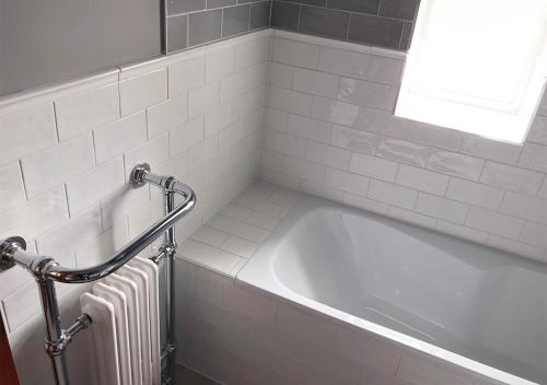 a white bath tub in a bathroom with a window at Andresna House in Corrigeenroe