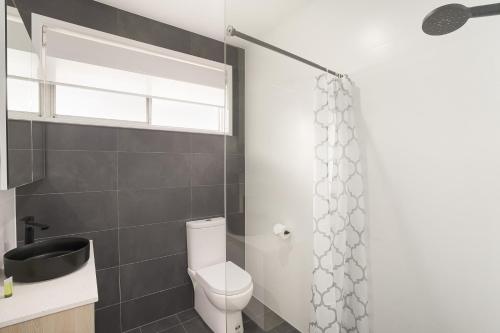a bathroom with a toilet and a shower at Adamstown Short Stay Apartments in Adamstown