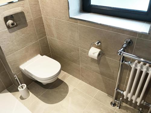 a bathroom with a toilet and a window and a radiator at Andresna House in Corrigeenroe