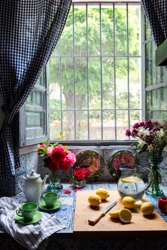 a table with lemons and flowers and a window at Finca San Juan Alojamiento Boutique in Constantina